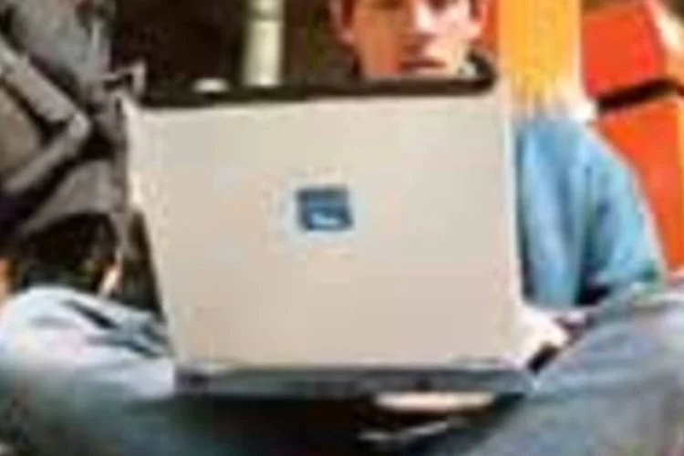 Jovem usa seu laptop numa estação de trens na França: o avanço da internet sem fio  (--- [])