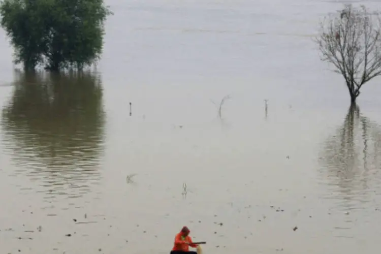 Homem pesca no rio Liuyang: território chinês enfrenta graves problemas de inundações (China Daily/Reuters)