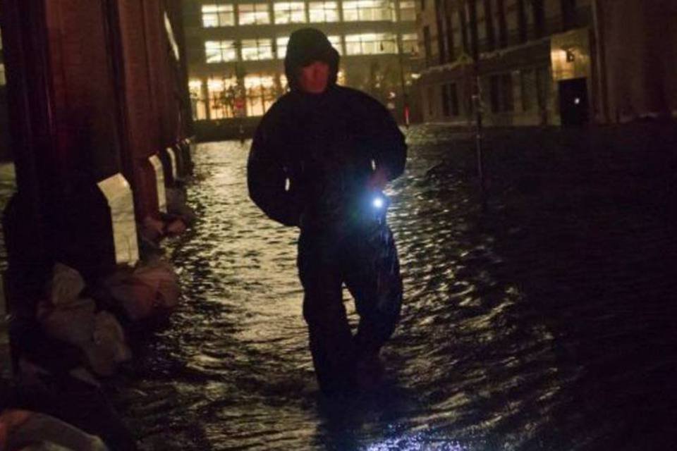 
	Seguran&ccedil;a anda em &aacute;rea alagada no distrito financeiro de Manhattan, Nova York, com a chegada do furac&atilde;o Sandy
 (Adrees Latif/Reuters)