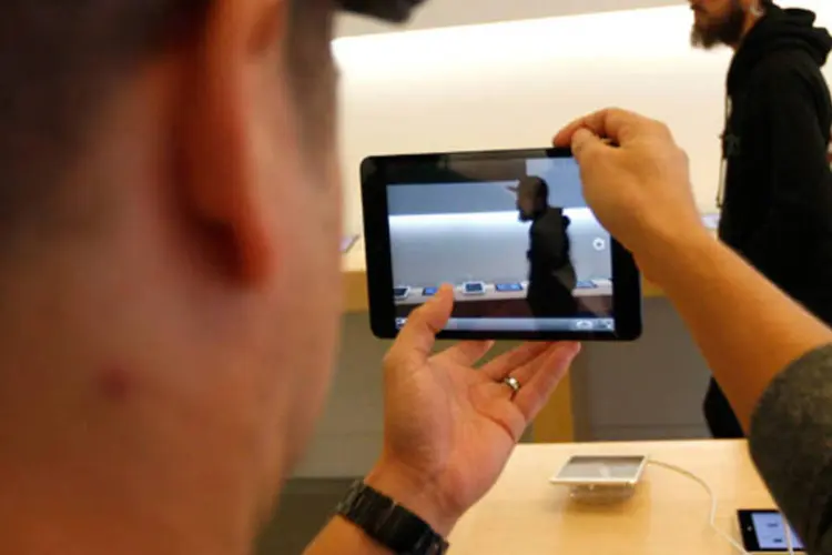 Homem testa câmera fotográfica do iPad Mini: lançamento do gadget da Apple teve filas menores (REUTERS/David McNe)