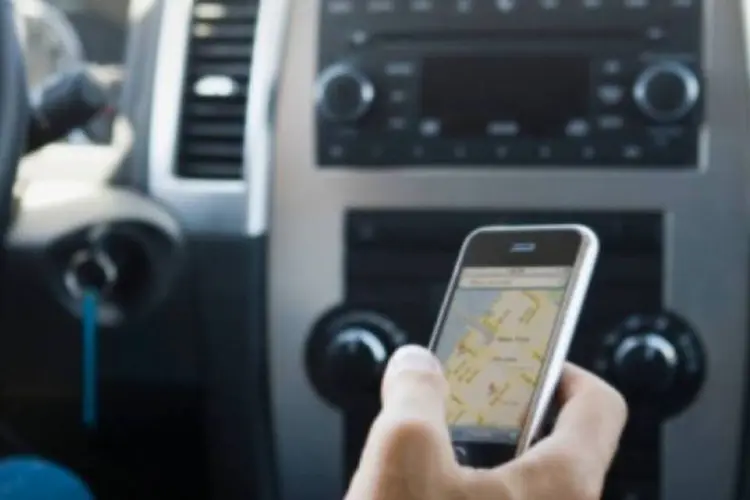 Homem usa iPhone enquanto dirige: a Apple parece estar tomando medidas para diminuir número de acidentes que envolvem distração do motorista ao usar smartphone (Getty Images)