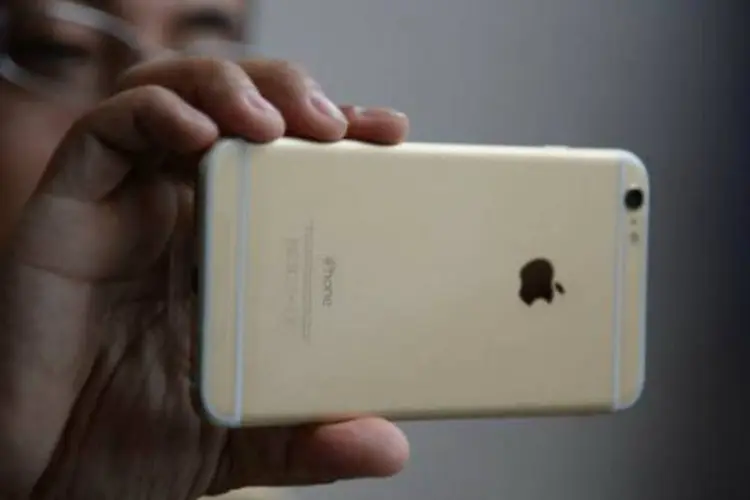 
	Homem usa iPhone 6 do lado de fora de loja da Apple
 (Robyn Beck/AFP)
