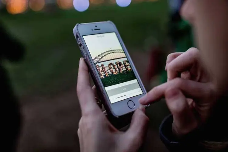 
	Jovem utiliza iPhone: ainda n&atilde;o se sabe exatamente por que raz&atilde;o mudar a data do celular transforma o aparelho em peso de papel
 (Cole Bennetts/Getty Images)