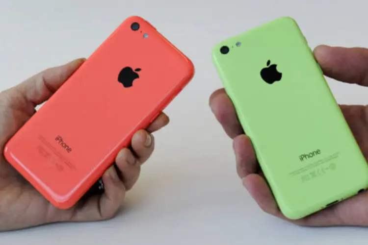 
	Pessoas seguram iPhone 5C: marca lidera pela primeira vez ranking das mais valiosas do mundo
 (David Paul Morris/Bloomberg)