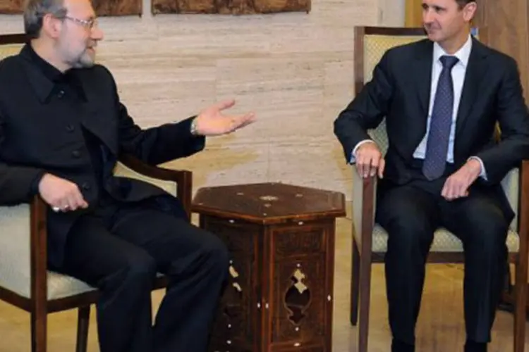 Ali Larijani (E) conversa com o presidente sírio, Bashar al-Assad, em Damasco: "o Irã continua a apreciar o papel de vanguarda da Síria no apoio à Resistência"
 (AFP)