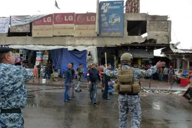 Policial iraquiano afasta pedestres de local do atentado, em frente a restaurante em Bagdá
 (Sabah Arar/AFP)