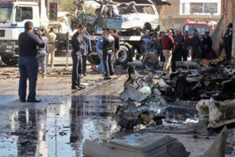 Iraquianos observam carro-bomba que deixou dois mortos no centro da cidade de Hilla (AFP)
