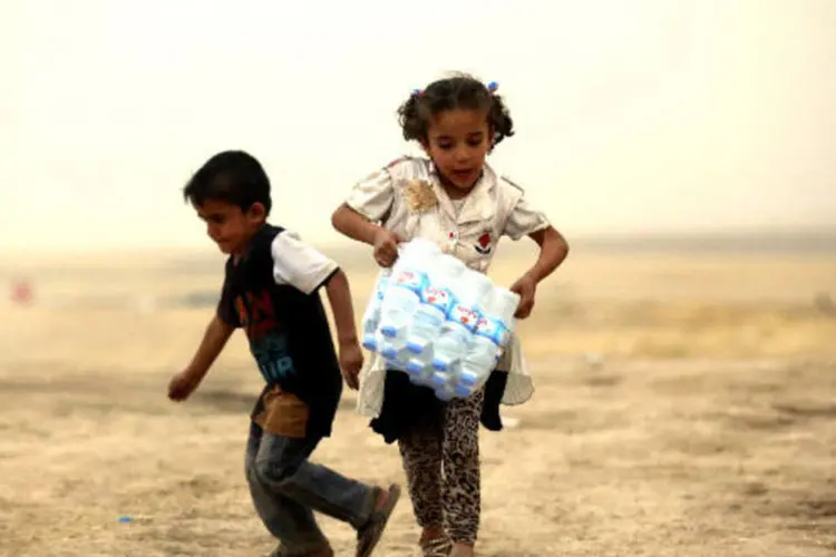 
	Menina carrega garrafas de &aacute;gua em Mossul. Ela &eacute; uma das milhares de pessoas em fuga por conta das invas&otilde;es do grupo radical sunita EIIL (Estado Isl&acirc;mico do Iraque e do Levante)
 (REUTERS)