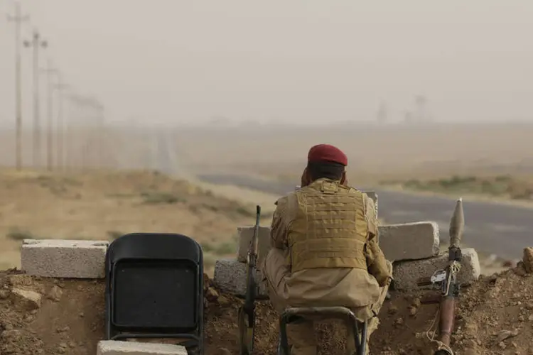 
	Um lutador curdo mant&eacute;m guarda em dire&ccedil;&atilde;o &agrave;s posi&ccedil;&otilde;es dos militantes do Estado isl&acirc;mico perto de Mosul, no norte do Iraque
 (REUTERS/Youssef Boudlal)