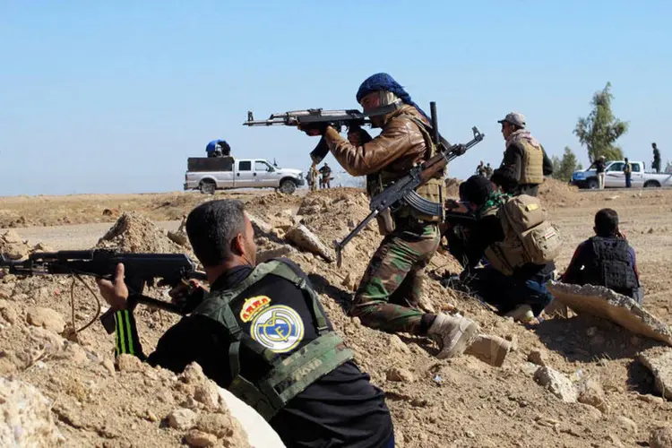 
	Combatentes disparam contra o EI no Iraque: for&ccedil;as iraquianas avan&ccedil;am pelas estradas para impedir a fuga dos jihadistas
 (Reuters)