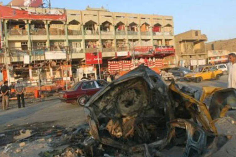 
	Iraquianos observam o local onde um carro-bomba explodiu em Bagd&aacute; nesta sexta-feira: os extremistas consideram que este m&ecirc;s sagrado &eacute; prop&iacute;cio para realizar a &quot;guerra santa&quot;
 (Ahmad al-Rubaye/AFP)