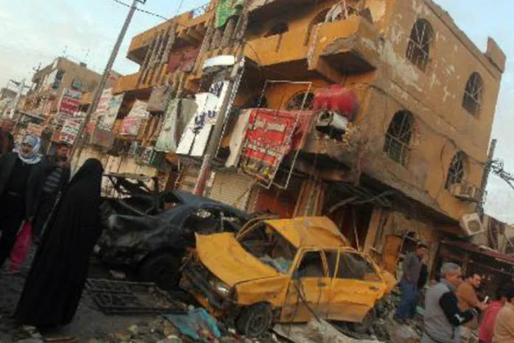 Iraquianos inspecionam área atingida por atentado com carro-bomba em Sadr City, Bagdá (Ahmad al-Rubaye/AFP)
