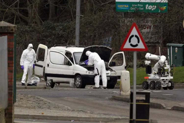 Oficiais forenses examinam uma van durante uma operação policial na estrada Letterkenny em Londonderry, na Irlanda do Norte  (Cathal McNaughton/Reuters)