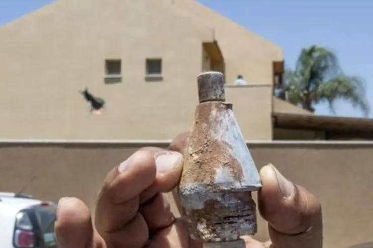 Israelense segura destroço de foguete lançado na cidade de Sderot, a partir da Faixa de Gaza (Jack Guez/AFP)