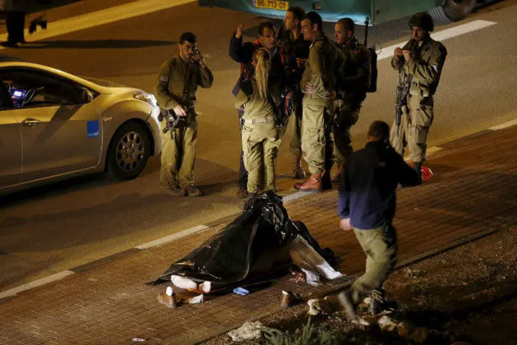 
	Soldados israelenses perto de corpo em cena de ataque de atirador palestino na Cisjord&acirc;nia
 (Ronen Zvulun/Reuters)