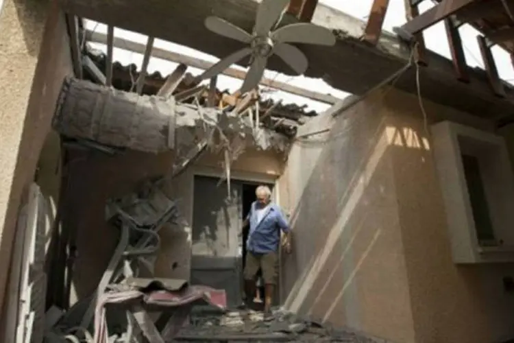 Israelense morador de um kibutz observa os estragos em sua casa após um disparo de foguete da Faixa de Gaza
 (Jack Guez/AFP)
