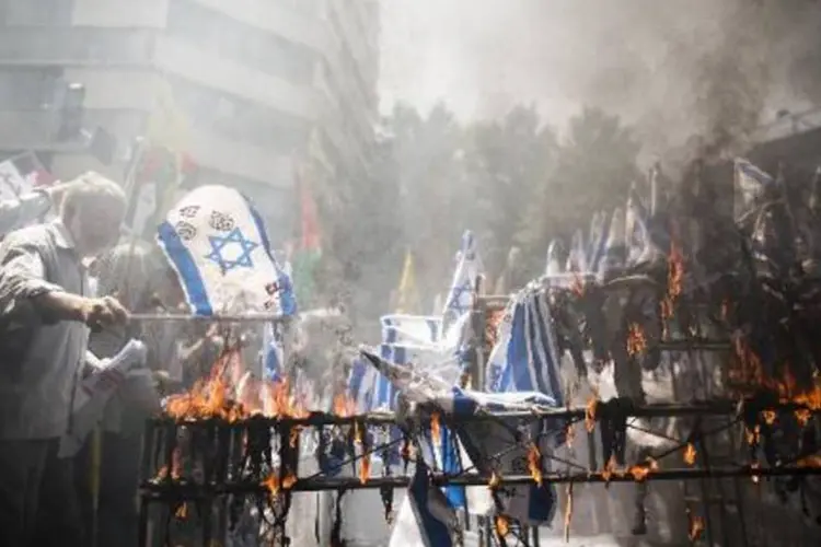 Manifestantes queimam bandeiras de Israel: mais de 800 palestinos já morreram (Behrouz Mehri/AFP)