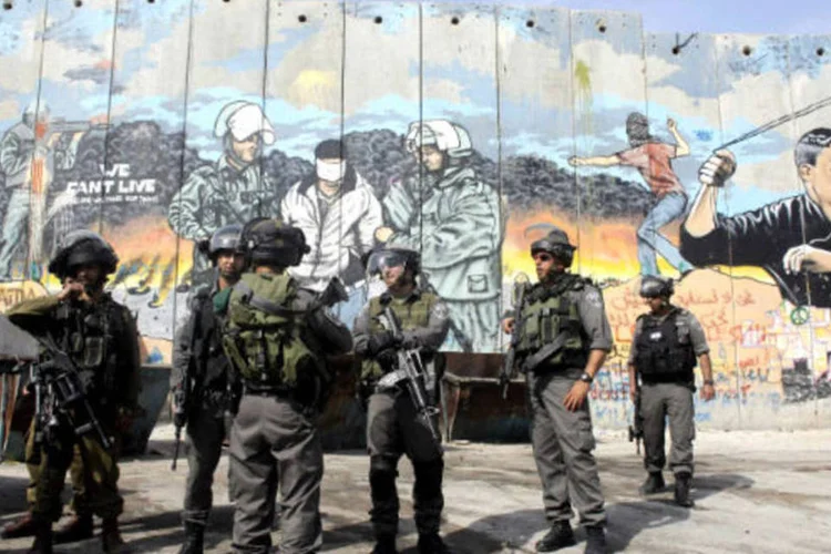 
	Soldados israelenses e guardas da fronteira conversam: no s&aacute;bado foram registrados na Cisjord&acirc;nia outros dois ataques similares com arma branca contra for&ccedil;as de seguran&ccedil;a israelenses
 (REUTERS/Ammar Awad)