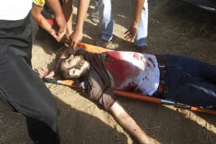Palestinos carregam o corpo de um dos mortos no ataque israelense
 (Mohammed Abed/AFP)