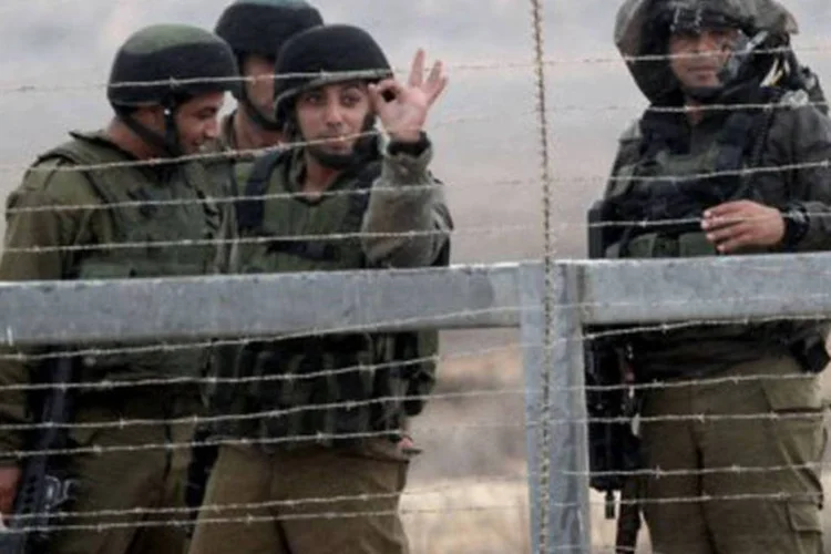 
	Soldados israelenses posicionados:&nbsp;comboio inclu&iacute;a um caminh&atilde;o com cinco tendas de campanha destinadas &agrave;s fam&iacute;lias da regi&atilde;o
 (Said Khatib/AFP)