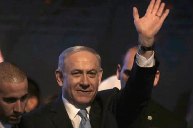 O primeiro-ministro Benjamin Netanyahu acena para simpatizantes na cidade de Tel Aviv depois de reivindicar a vitória
 (MENAHEM KAHANA/AFP)