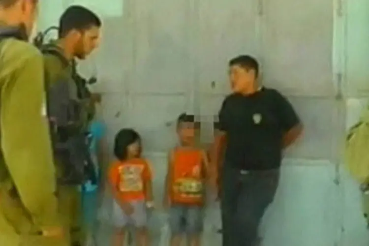 Soldados israelenses cercam menino palestino de 5 anos Wadi Maswadeh após sua detenção em Hebron (BTselem/Divulgação via REUTERS TV)