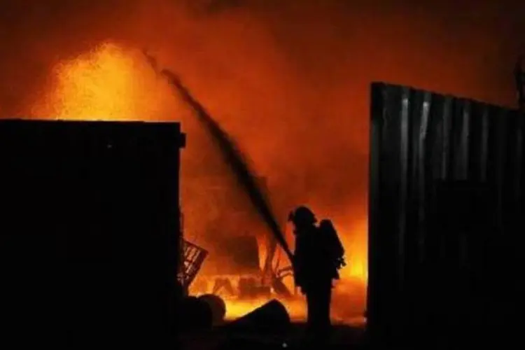 Bombeiro apaga chamas após ataques aéreos na Faixa de Gaza (AFP)