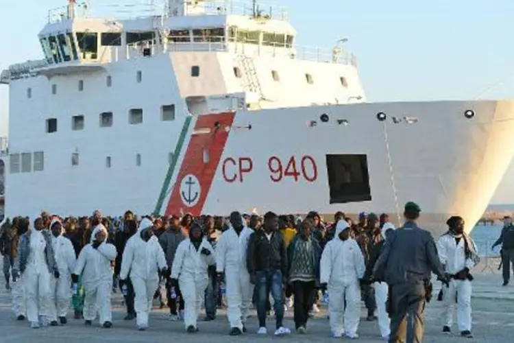 Imigrantes naufrágos desembarcam de barco de resgate no porto de Augusta, Itália (AFP/ GIOVANNI ISOLINO)