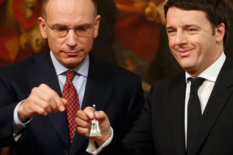 O novo premiê da Itália Matteo Renzi (d) toca um sino para marcar seu primeiro encontro de gabinete, ao lado do seu predecessor Enrico Letta (e) (REUTERS/Tony Gentile)
