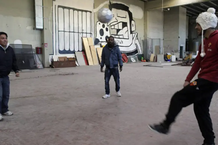 Desemprego, Henok Mulugeta joga futebol com seus amigos em prédio onde vive com sua namorada em Roma, na Itália (Tony Gentile/Reuters)