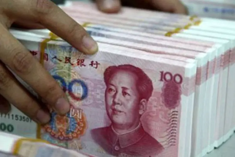 O iuane teve novo recorde de alta ante o dólar depois de o banco central fixar em baixa a taxa de câmbio de referência em meio à desvalorização generalizada da divisa americana (AFP)