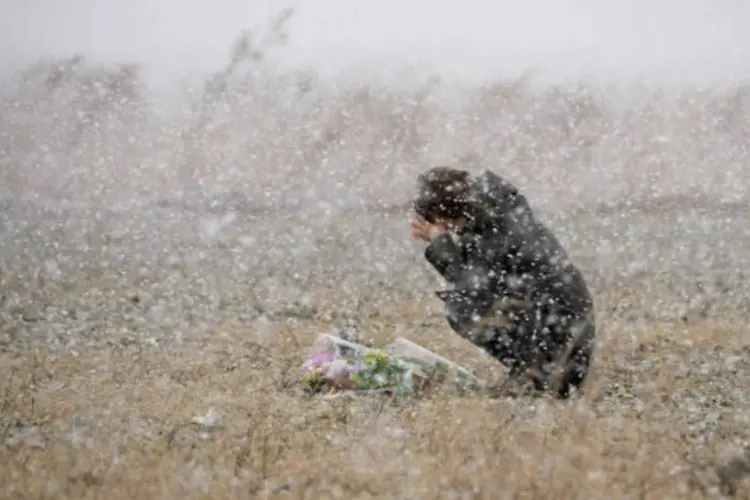 Mulher reza em meio à neve em Iwate, no Japão, por vítimas de tsunami: além das perdas humanas, muitas pessoas abandonaram a região para tentar esquecer a tragédia (Kyodo/Reuters)