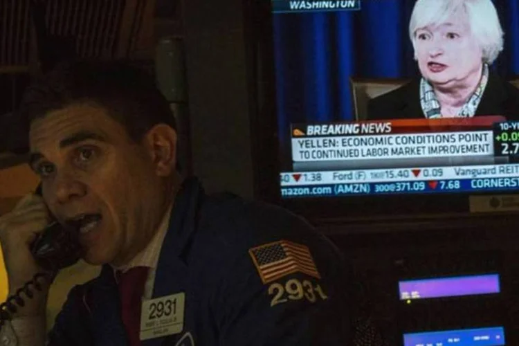 Tela exibe a conferência de imprensa com a chair do Federal Reserve (Fed), Janet Yellen, na Bolsa de Valores de Nova York (NYSE) (Brendan McDermid/Reuters)