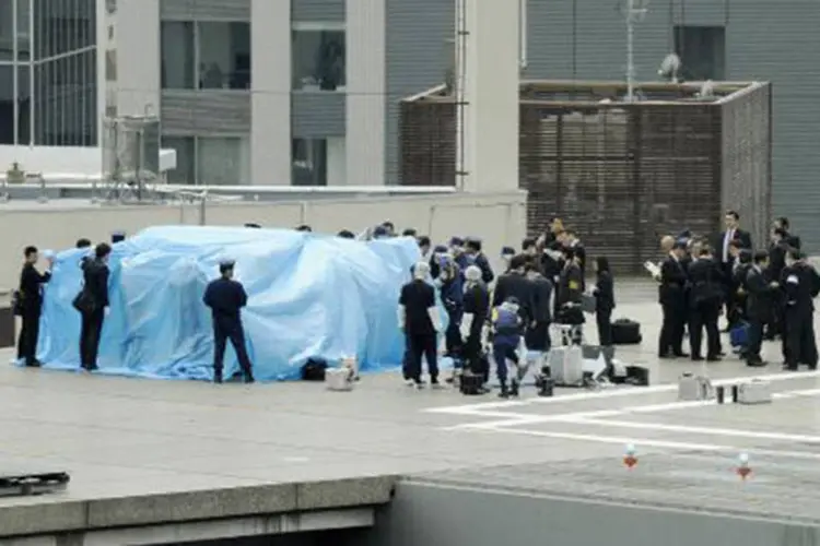 Polícia japonesa usa pano azul para cobrir e inspecionar drone, em 22 de abril de 2015 em Tóquio
 (AFP)