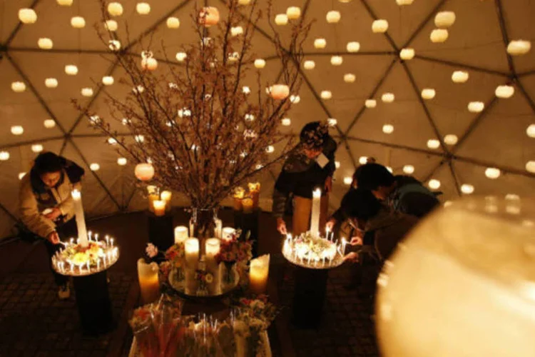 Visitantes acendem velas em homenagem às vítimas do terremoto e tsunami que atingiram o Japão em 2011 (REUTERS / Issei Kato)