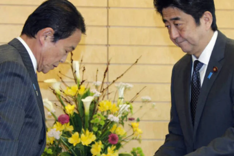 Primeiro-ministro japonês Shinzo Abe recebe documento do ministro das Finanças, Taro Aso  (REUTERS / Koji Sasahara)