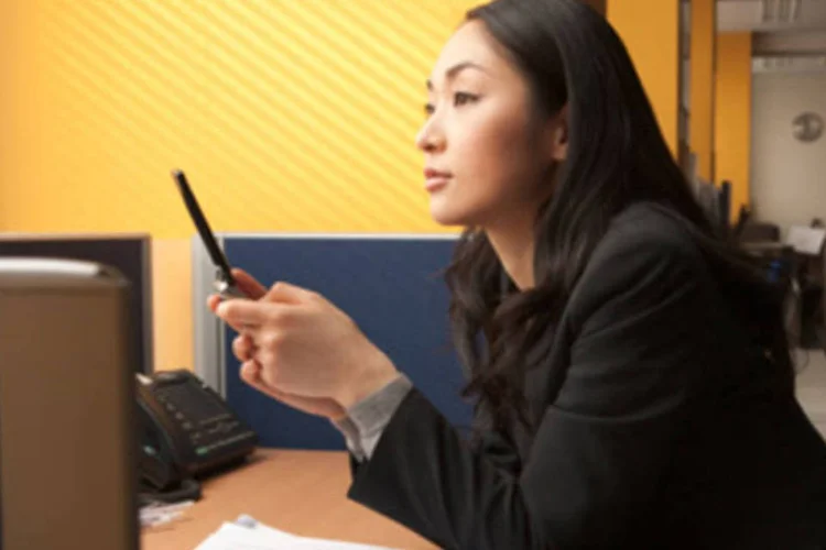 Executiva japonesa usa celular durante expediente: aplicativos móveis exclusivos para redes sociais como o Facebook fazem sucesso entre os usuários nipônicos (.)