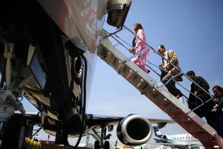 
	Pessoas entrando em um jato Lineage 1000E, da Embraer, durante uma feira de neg&oacute;cios
 (Carlos Barria/Reuters)