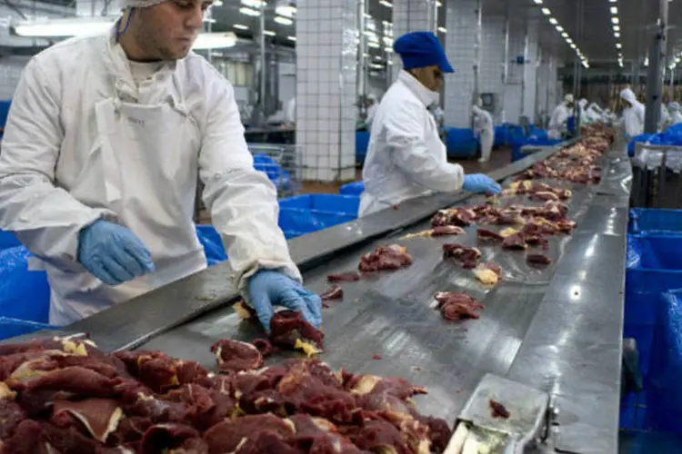 
	Funcion&aacute;rios manipulam carne em frigor&iacute;fico da JBS: na JBS, sediada em S&atilde;o Paulo, os humanos est&atilde;o desossando bezerros e novilhas mais r&aacute;pida e eficientemente do que muitos
 (Diego Giudice/Bloomberg)