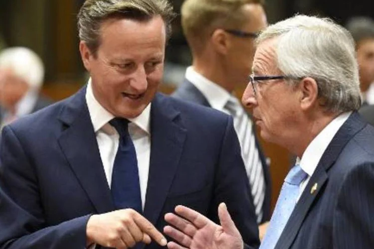 
	Jean-Claude Juncker com David Cameron: &quot;afirmei que a Comiss&atilde;o lutaria contra a evas&atilde;o e a fraude fiscal. Quero que todo mundo saiba que n&atilde;o s&atilde;o palavras soltas no ar&quot;
 (John Thys/AFP)
