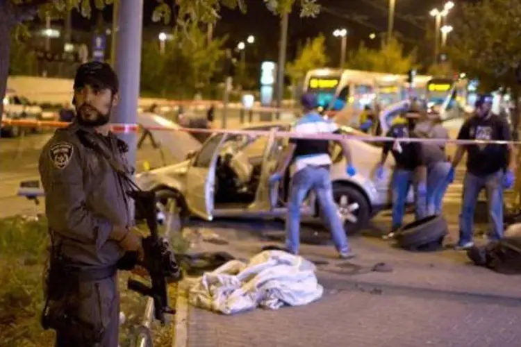 Policiais israelenses isolam a área em que um carro foi jogado sobre pedestres matando duas pessoas (Menahem Kahana/AFP)