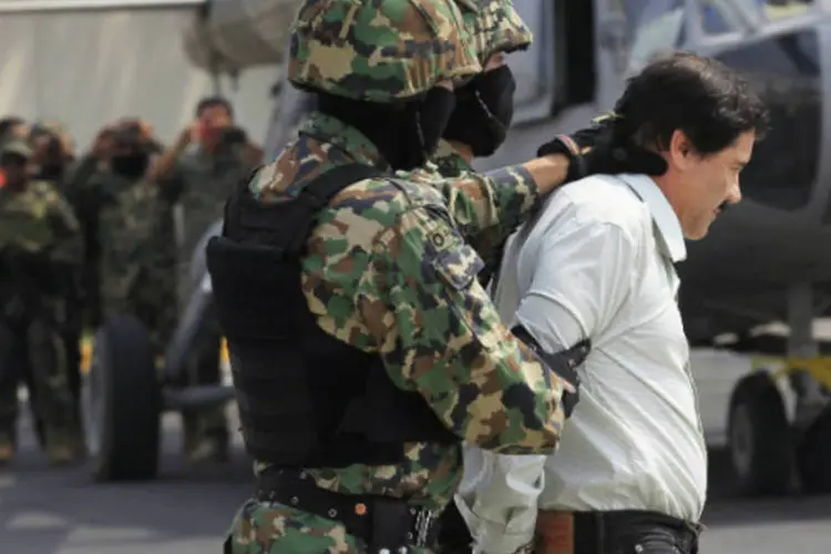 
	Joaquin &quot;El Chapo&quot; Guzman &eacute; escoltado por soldados na Cidade do M&eacute;xico: ele foi capturado neste fim de semana
 (Henry Romero/Reuters)
