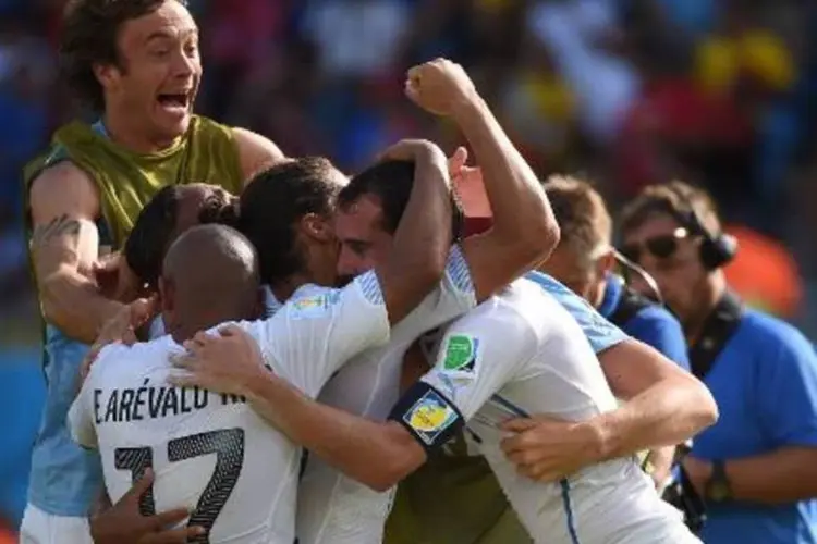 Jogadores uruguaios comemoram vitória sobre a Itália na Copa (Emmanuel Dunand/AFP)