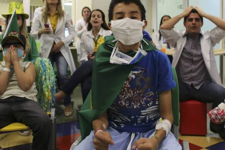 Pacientes assistem ao jogo do Brasil com médicos e enfermeiras no Instituto de Tratamento do Câncer Infantil, em São Paulo (Nacho Doce/Reuters)