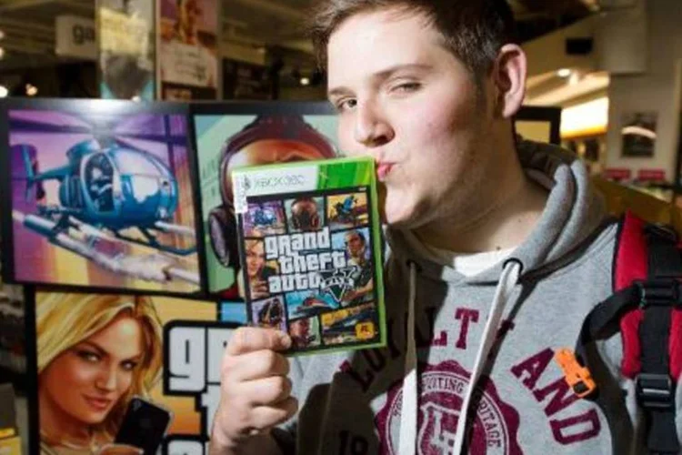 Jovem britânico posa com uma cópia do videogame Grand Theft Auto 5 em uma loja de departamentos do centro de Londres (Leon Neal/AFP)