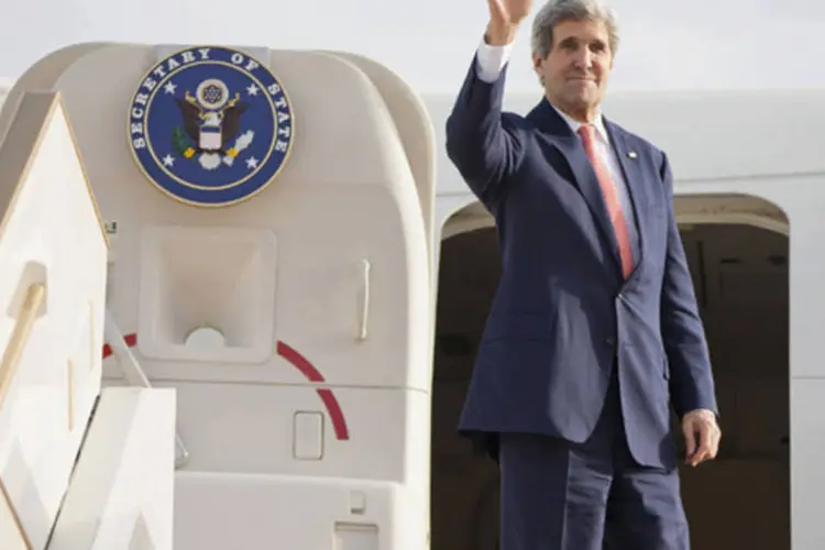Secretário de Estado norte-americano, John Kerry, acena antes de decolar no aeroporto internacional de Abu Dhabi (Evan Vucci/Reuters)