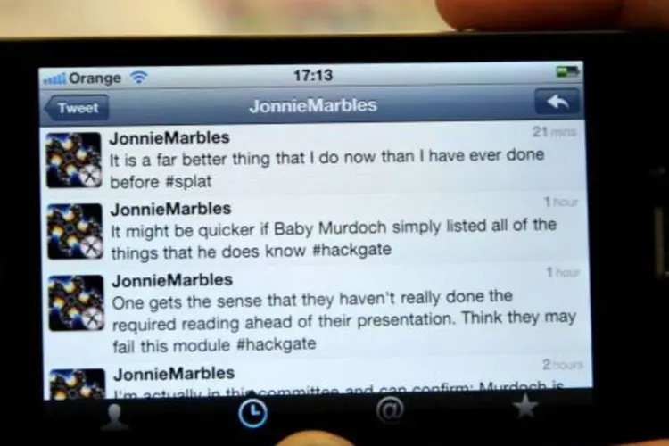 Pessoa visualiza no iPhone, dentro da audiência, a conta no Twitter do comediante Jonnie Marbles (Getty Images)