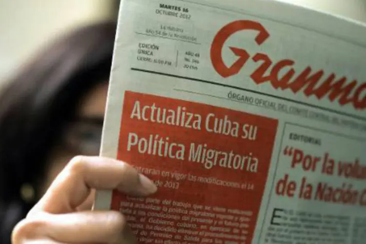 Uma mulher lê um exemplar do jornal cubano Granma: "o que muda agora é o cenário e as nuances", disse o Partido Comunista (Adalberto Roque/AFP)
