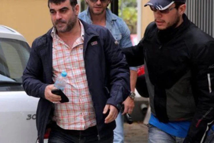 Jornalista grego Costas Vaxevanis é escoltado por policiais no dia 28 de outubro de 2012 em Atenas: ele insiste que se limitou a cumprir o dever de jornalista
 (Georgia Panagopoulo)