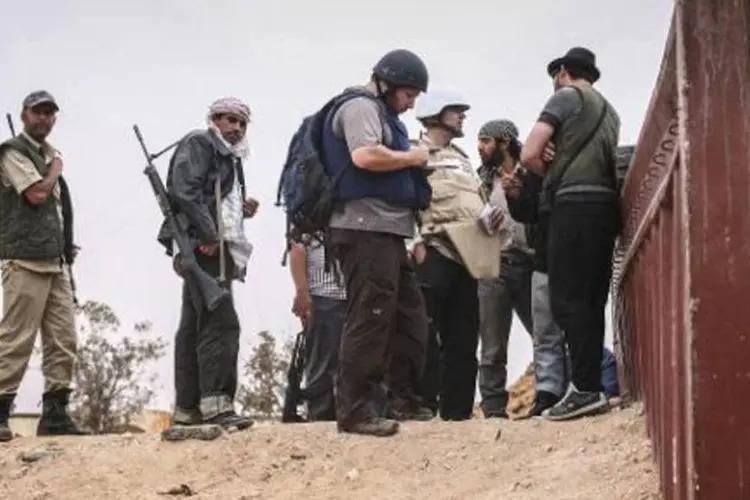 Sotloff (de capacete preto) conversa com rebeldes líbios na linha de frente de Al-Dafniya (Etienne de Malglaive/AFP)